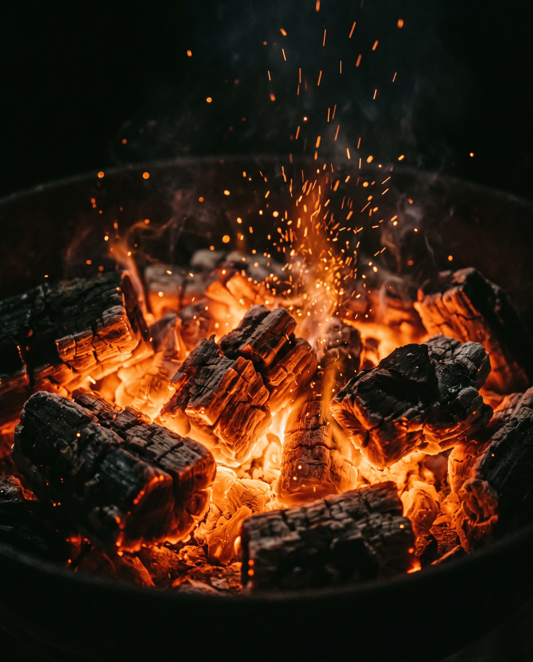 Glowing charcoal and oak embers in the grill